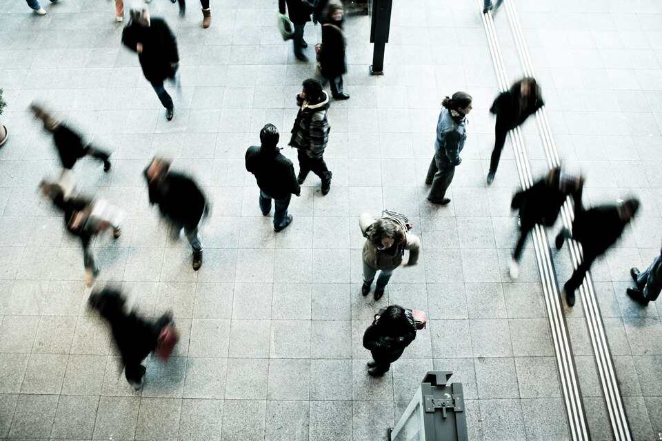 des personnes marchant sur un sol en béton gris en journée